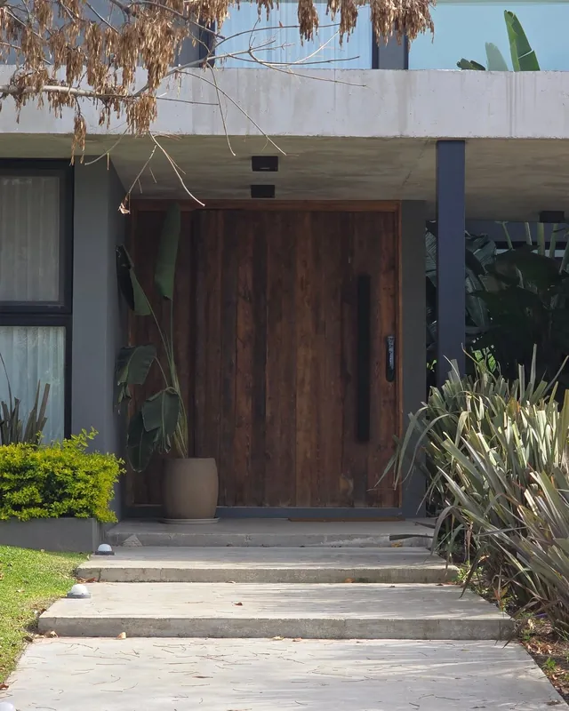 Puerta de pinotea al final de un camino de jardín con escalones de piedra