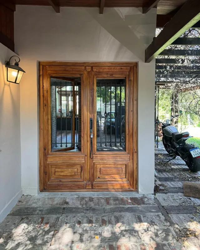 Puerta colonial doble con rejas bajo una pérgola