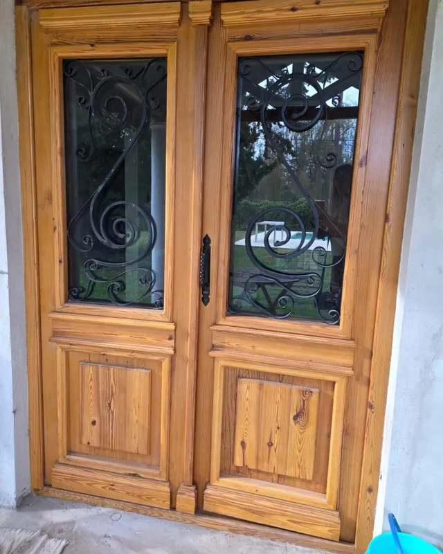 Puerta colonial doble con vidrios y hierro forjado