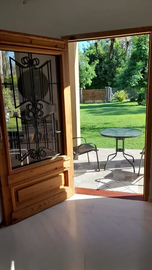 Puerta colonial abierta hacia un jardín