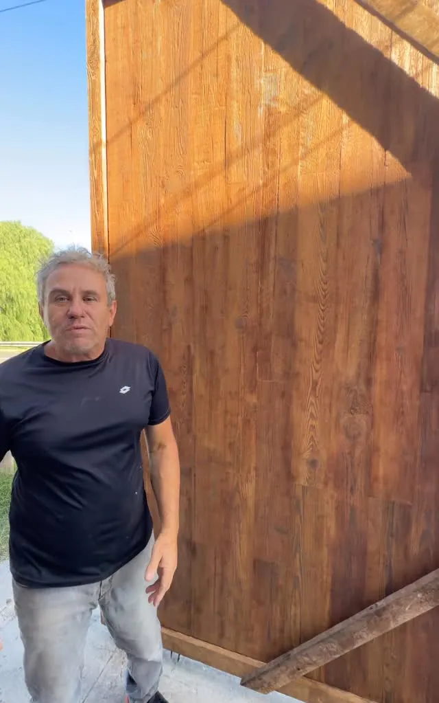 Nuestro papá al lado de una puerta grande terminada